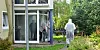 Beamte der Polizei und Mitarbeiter eines Bestattungsunternehmens arbeiten vor einem Mehrfamilienhaus.