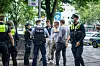 Polizisten und drei Touristen stehen am Bahn-Eingang auf der Reeperbahn