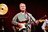 Er steht am Mikrofon, Gitarre umgeschnallt