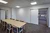 In den Gemeinschaftsräume stehen Tische Stühle, im Hintergrund ist die Küche zu sehen