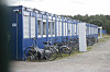 Fahrräder und ein Möbelstück stehen vor Wohncontainern in der Flüchtlingsunterkunft.