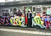 Ein Zugbegleiter schaut aus einem vollgeschmierten Waggon.