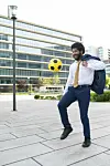 Geschäftsmann spielt mit Fußball.