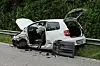 Ein zerstörtes weißes Auto steht am Fahrbahnrand