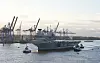 Der riesige Flugzeugträger wurde mit mehreren Schleppern in den Hafen gezogen.