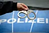 Ein Polizist hält ein Paar Handschellen