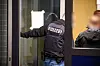 Polizei geht durch eine Glastür in ein Haus