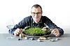 Mopo-Autor Frank Wieding sitzt vor einem Teller mit Gras, davor liegen Steine.