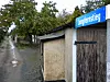 Der Jungfernstieg in Quedlinburg: ein umgepflasterter Weg mit Pfützen, rechts alte Garagen mit Holztoren