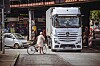 Eine alte Dame mit Rad versucht vor einem Laster die Stresemannstraße zu überqueren.