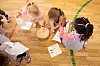 Drei Mädchen spielen in einem Kindergarten mit einem Musikinstrument.