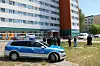 Polizei steht vor dem Wohnblock.