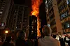 Menschen betrachten die Flammen, die ein Gebäude verschlingen, nachdem im Wang Fuk Court ein Feuer ausgebrochen ist.
