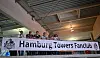 Fanklub-MItglieder posieren auf der Tribüne mit einem Banner