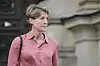 Frau in rosa Bluse vor Gerichtsgebäude