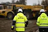 Zwei Mitarbeiter der Firma „Northvolt“ gehen über die Baustelle in Heide.
