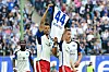 Robert Glatzel und Miro Muheim halten auf dem Spielfeld ein Trikot von Mario Vuskovic hoch