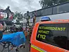 Mithilfe einer Drehleiter holen Feuerwehrmänner die Person aus dem Reisebus.