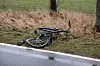 Ein verbeultes Fahrrad liegt am Straßenrand.