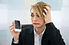 Eine Frau hält ihr kaputtes Smartphone in der Hand.