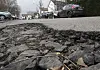 Ein Schlagloch klafft auf der Straße.