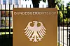 Der Schriftzug „Bundesgerichtshof“ und ein deutscher Bundesadler sind auf einer Stele an einem Zaun vor dem Hauptgebäude vom Bundesgerichtshof (BGH) in Karlsruhe (Baden-Württemberg) zu sehen.