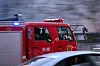 Einsatzkräfte in einem Feurwehrwagen.