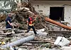 Zwei Feuerwehrleute gehen in dem Dorf im Kreis Ahrweiler nach dem Unwetter mit Hochwasser durch den Schutt. Mindestens sechs Häuser wurden durch die Fluten zerstört.