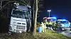Einsatzkräfte von Polizei und Feuerwehr arbeiten neben einem verunfallten Lastwagen auf der Autobahn 1.