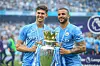Kyle Walker und John Stones präsentieren die Premier League-Trophäe.