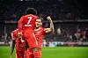 Leon Goretzka hebt Serge Gnabry beim Jubeln hoch.