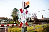 Eine Ampel an einem Bahnübergang an der zweigleisigen Bahnstrecke nahe Ihrhove leuchtet vor einer Zugdurchfahrt rot.