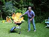Mann steht am Grill und erlebt Stichflamme