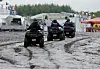 Polizisten auf Quads sind auf dem schlammigen Festivalgelände unterwegs.