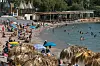 Zahlreiche Menschen baden an einem griechischen Strand.