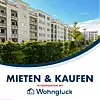 Wohnhäuser hinter Grünanlage, unten Werbetext „Mieten & Kaufen“ mit Logo WohnGlück.