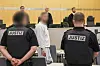 Der Angeklagte (M.) im grauen Jogginganzug vor dem Düsseldorfer Oberlandesgericht. Der 50-Jährige aus der rechtsextremen Szene in Dortmund soll zu Attentaten auf bekannte Politiker aufgerufen haben.