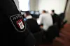 Der angeklagte Polizeibeamte (2.v.r) sitzt zwischen seinen Anwälten im Gerichtssaal zu Beginn des Prozesses wegen Körperverletzung im Amt.