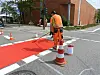 Ein Arbeiter färbt die Straße mit roter Farbe.