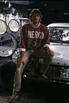 Peter Illmann sitzt auf der Motorhaube eines weißen Autos.