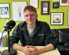 Der Schauspiler Johannes Hegemann sitzt vor einem Podcast-Mikrofon