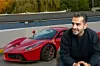 Auto-Moderator Hamid Mossadegh sitzt vor einem roten Ferrari LaFerrari.