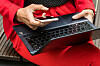 Eine Frau hält ein Smartphone und ein Laptop in den Händen