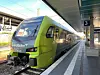 Grün-weißer Nordbahn-Zug steht an einem überdachten Bahnsteig neben Gleis 3.