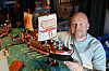 Ein Mann hält ein Playmobil-Schiff in den Händen.