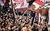 St. Pauli-Fans strecken im Block die Fäuste und schwenken mit Fahnen.