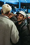 Veranstalter Emil Pourkian mit Cap spricht mit Gästen im Parkhaus während des Events.