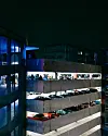 Mehrere auffällig gestaltete Fahrzeuge stehen nebeneinander in einem beleuchteten Parkhaus.