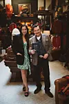 Meisun Farhat und Ben Bernschneider stehen zwischen Gästen in einem Geschäft für klassische Herrenmode.