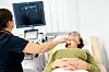 Eine Frau lässt ihre Schilddrüse in einer Klinik untersuchen.